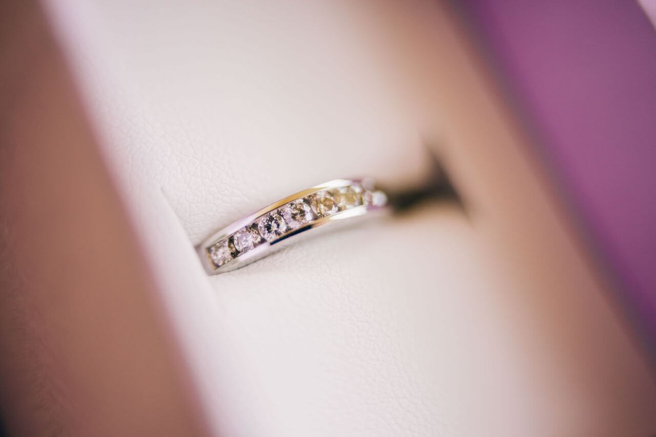 Close-up image of a silver channel diamond wedding ring in a white ring box