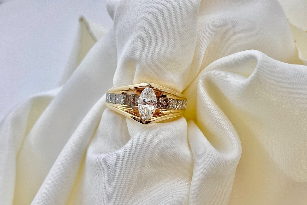 gold and diamond ring on a white cloth background