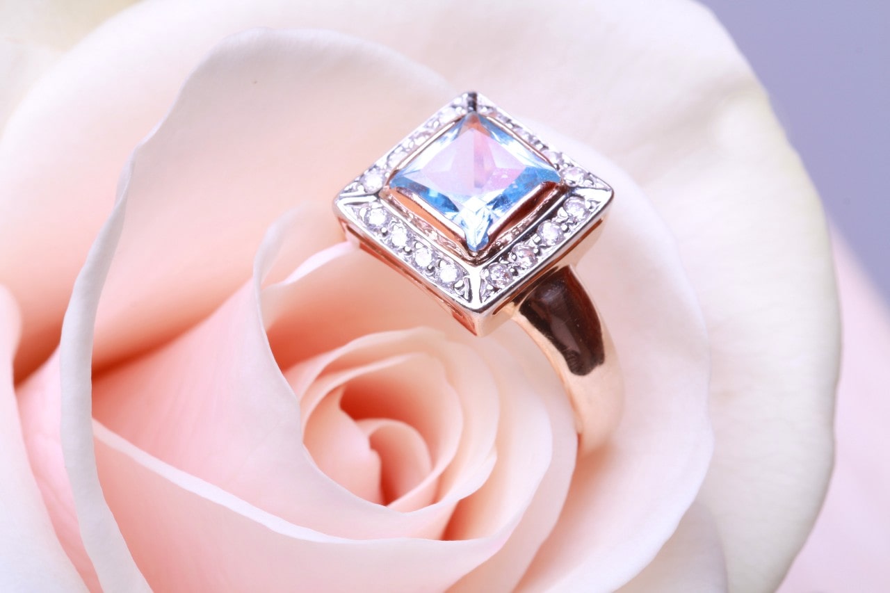 a diamond engagement ring nestled inside a pink rose