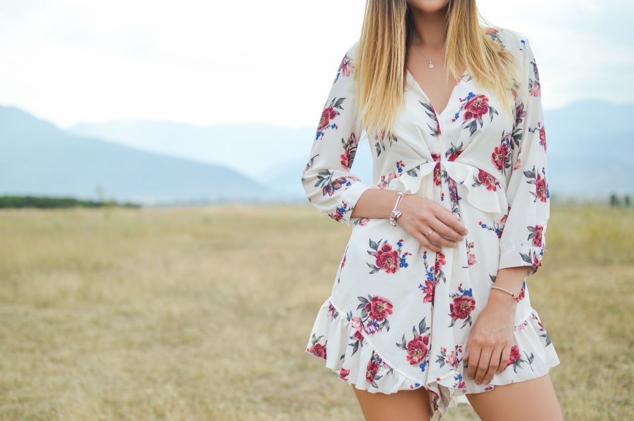 a lady standing in a field wearing fashion bracelets