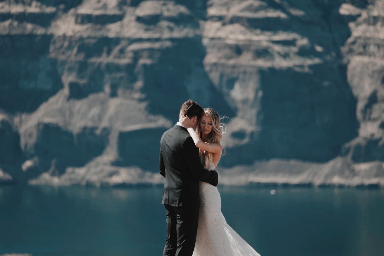bride and groom embracing next to a canyon