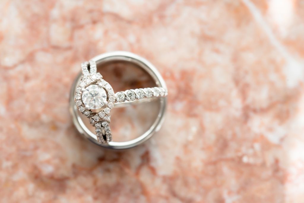Engagement ring with diamond pave and halo sitting on a wedding band