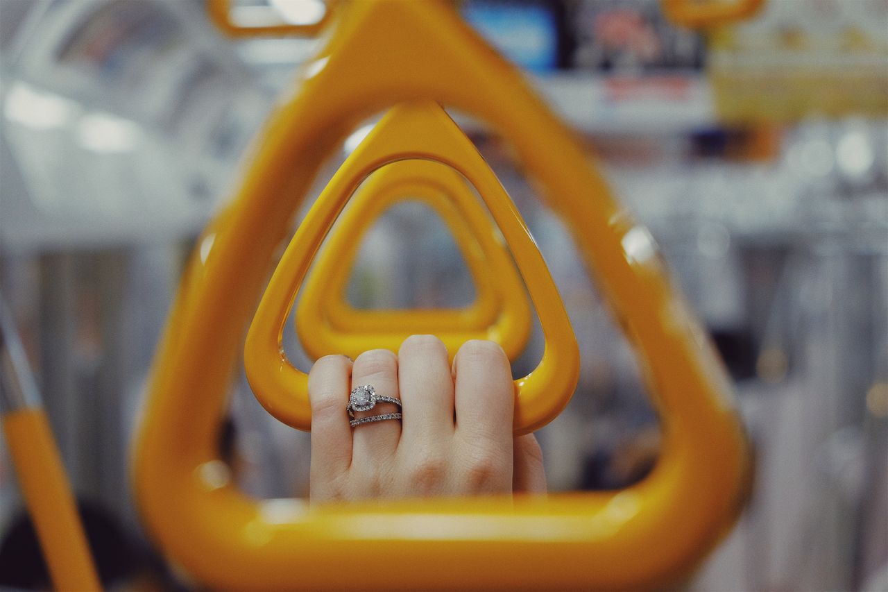 A married woman hangs onto the bar while riding the subway