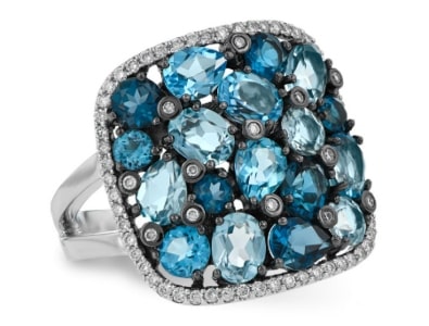 A blue topaz cocktail ring features a halo of diamonds