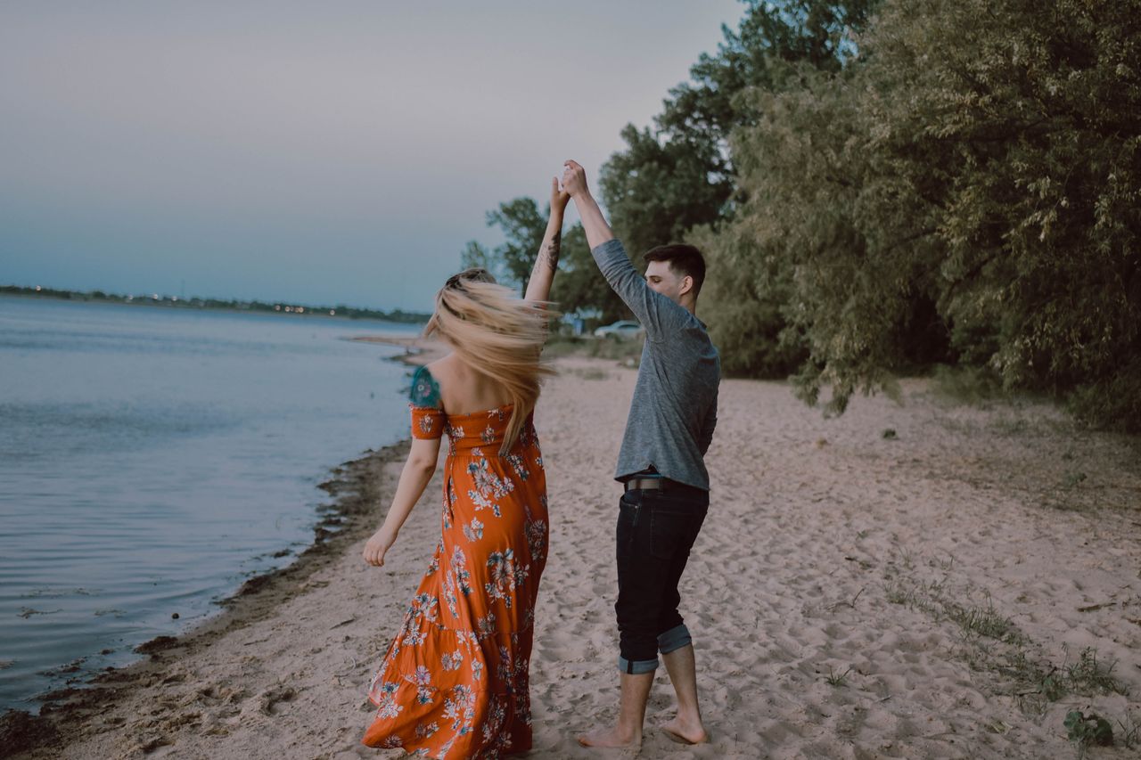 Couple holding hands and dancing on the beach