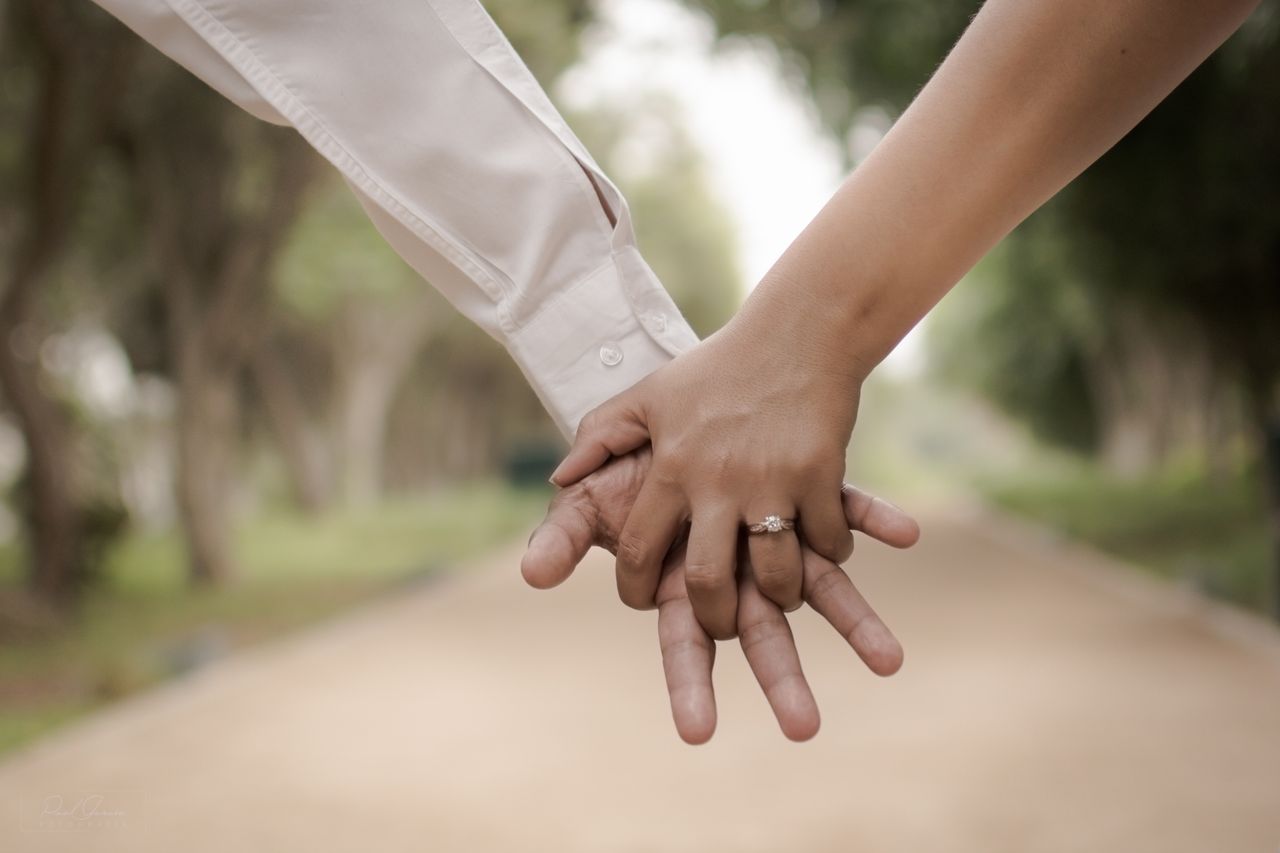 Close up of couple holding hands outside
