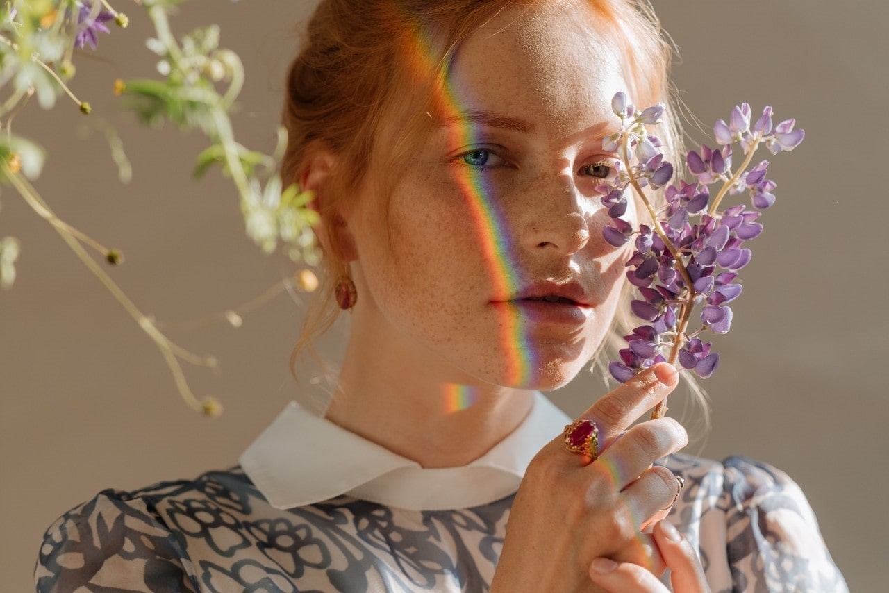 A lady wearing fashion rings and holding flowers