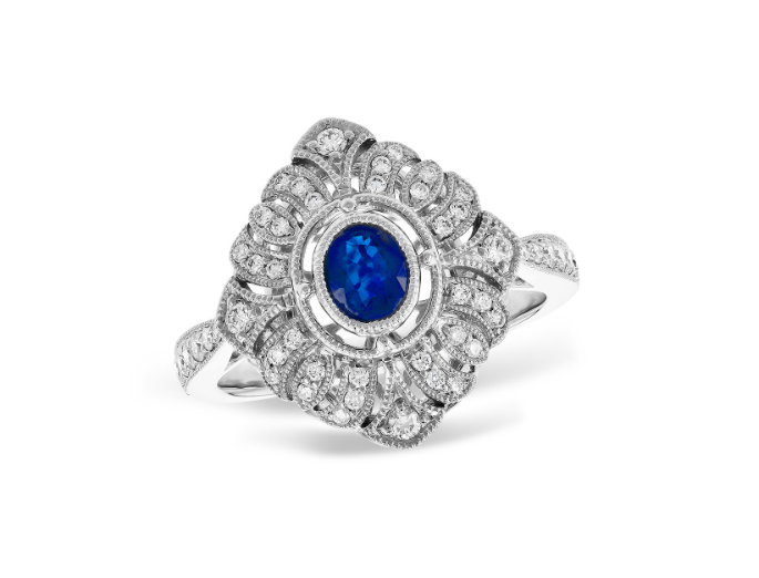 A white gold ornate diamond ring with oval sapphire at a center